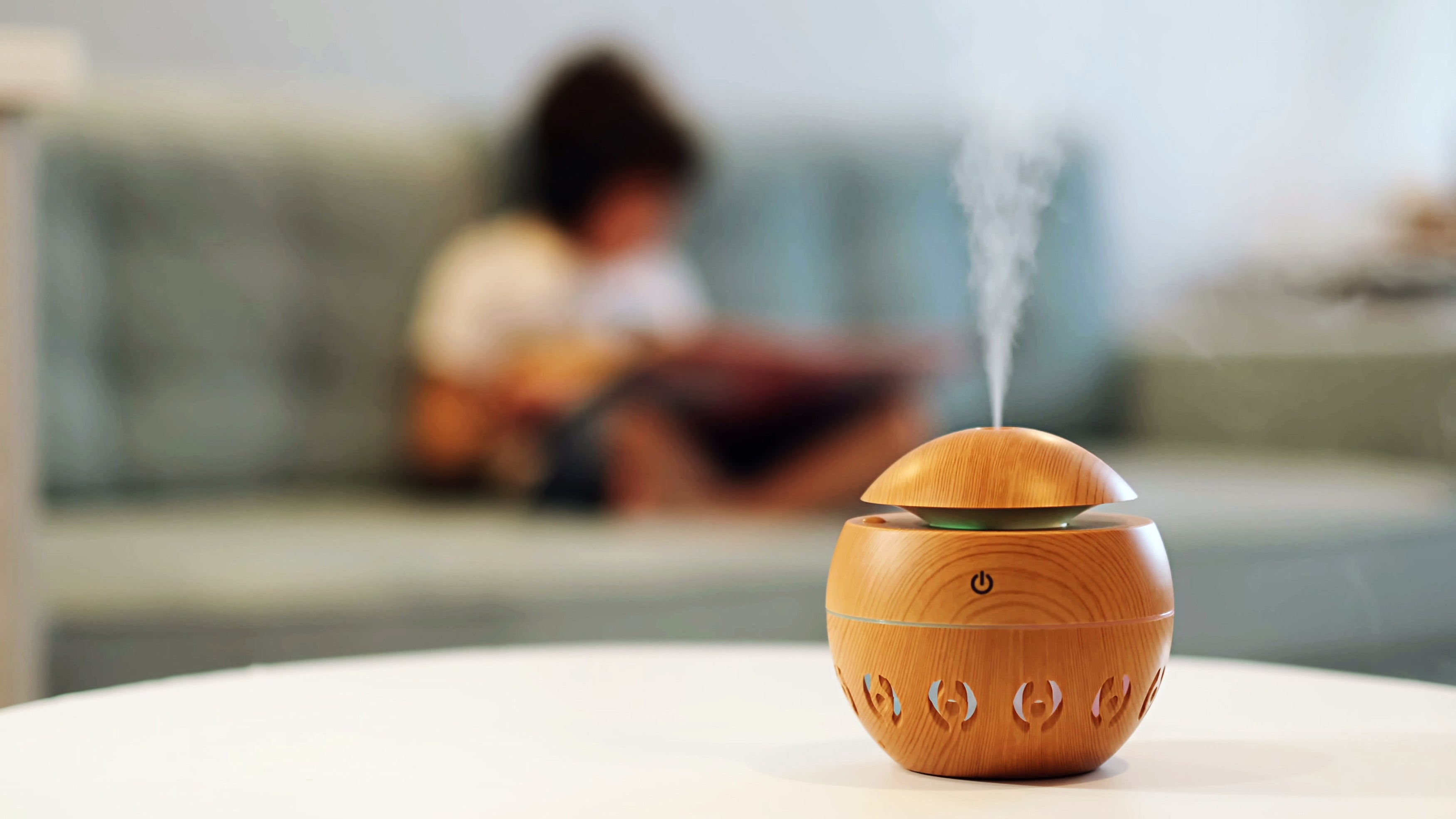 Modern aroma diffuser with mist on a white table