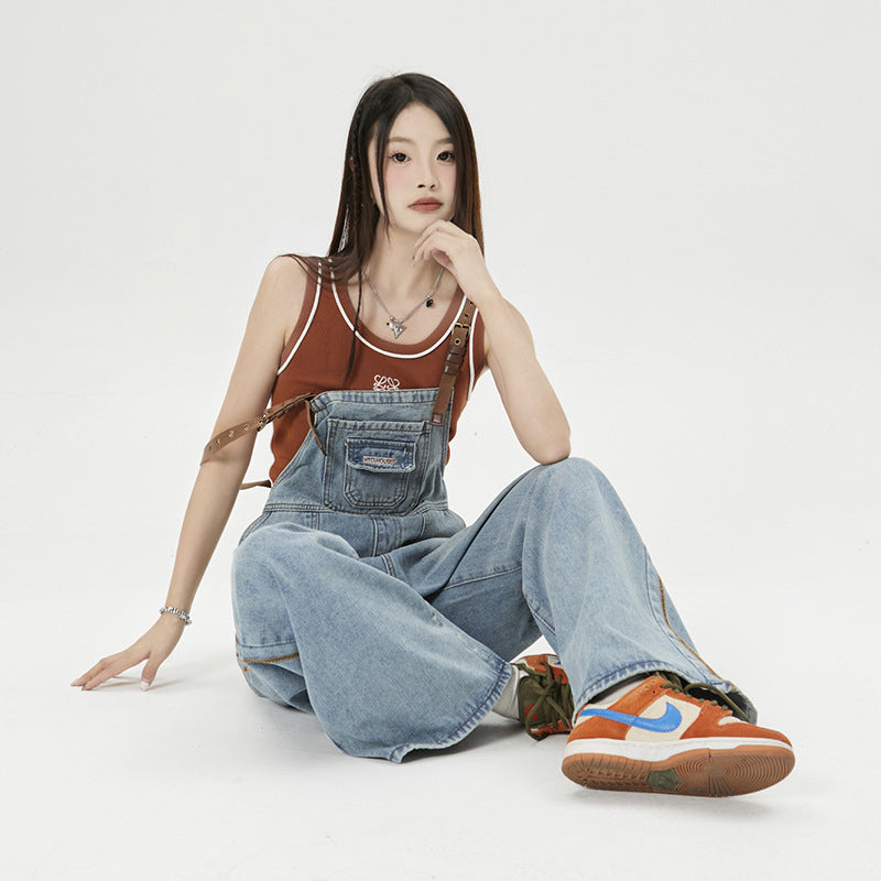 Gebaechte blaue Jeans mit lockeren Trägern