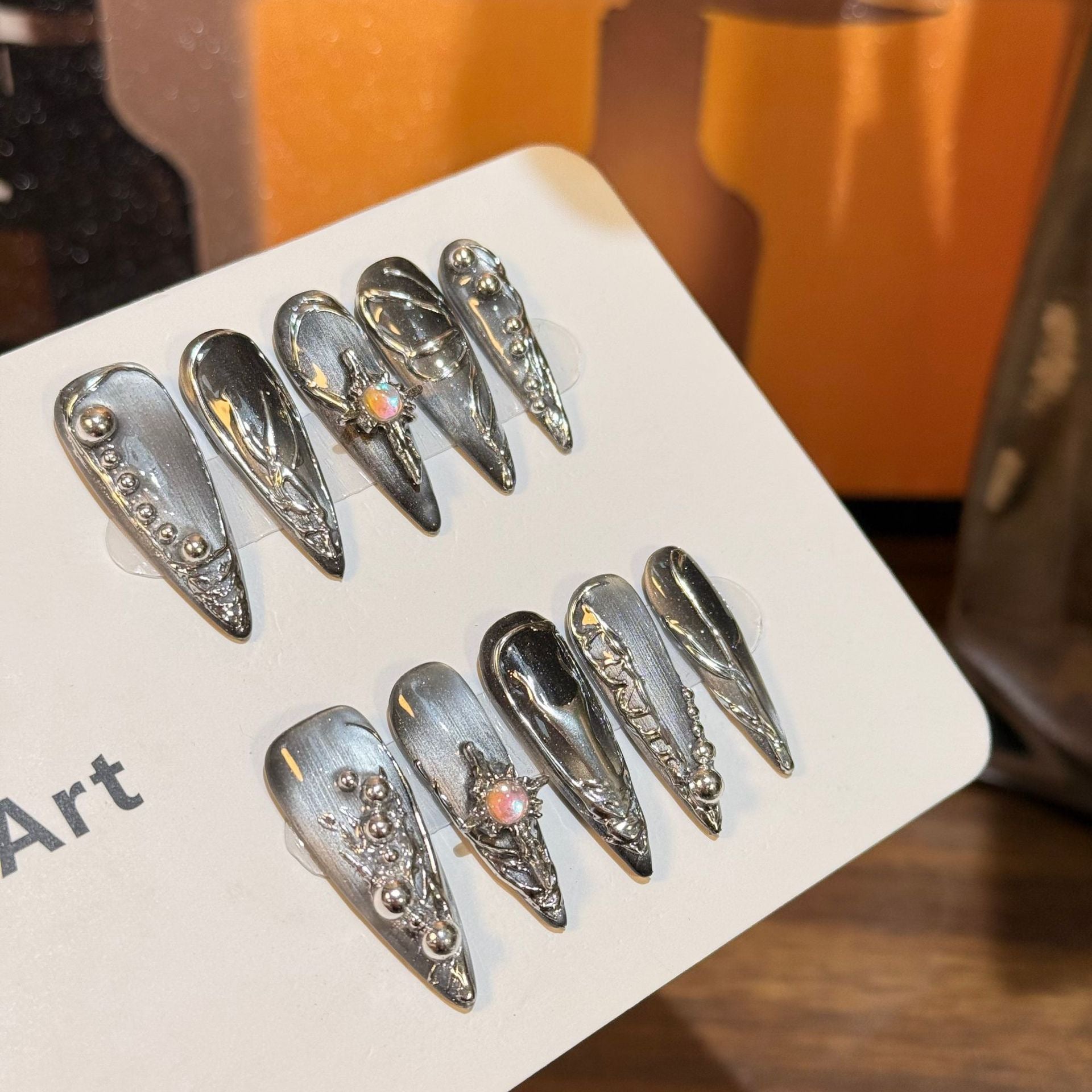 Dunkelgraue Cat Eye Nägel mit Kreuz-Herz Muster